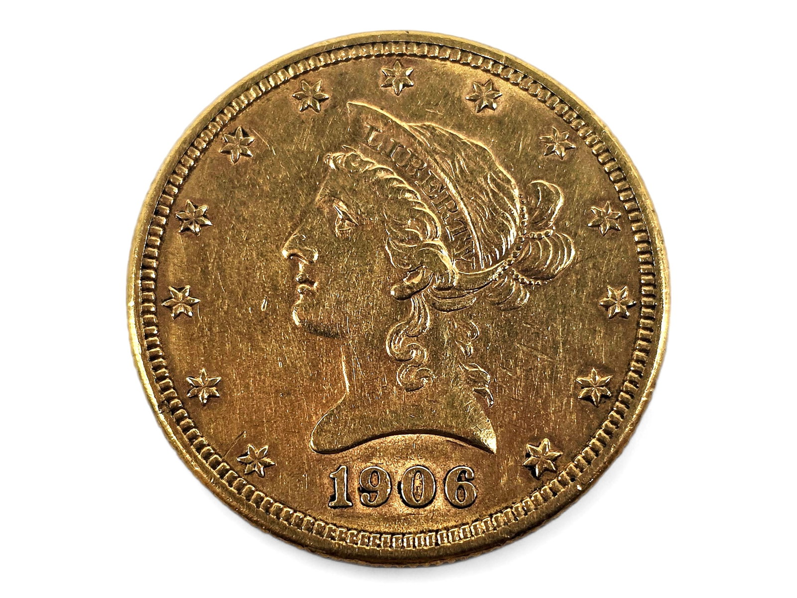 1906 Coronet Head Ten Dollar Gold Eagle: An antique 1906 Coronet Head Gold Eagle depicting Liberty facing left and encircled by thirteen stars on the obverse, with a heraldic eagle bearing the Union shield on the reverse. Designed by Christi
