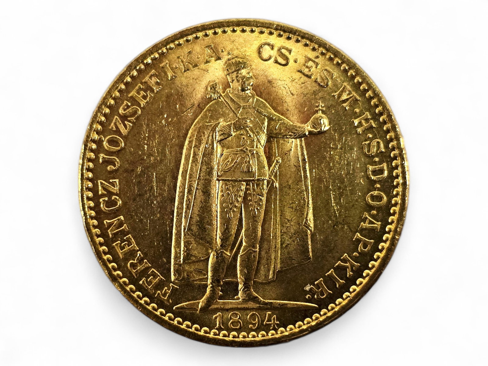 1894 Hungarian 20 Korona Gold Coin: An antique Hungarian 20 Korona gold coin dated 1894 and issued during the reign of Emperor Franz Joseph I (1830-1916). The obverse depicts the monarch standing in ceremonial robes and holding the Orb 