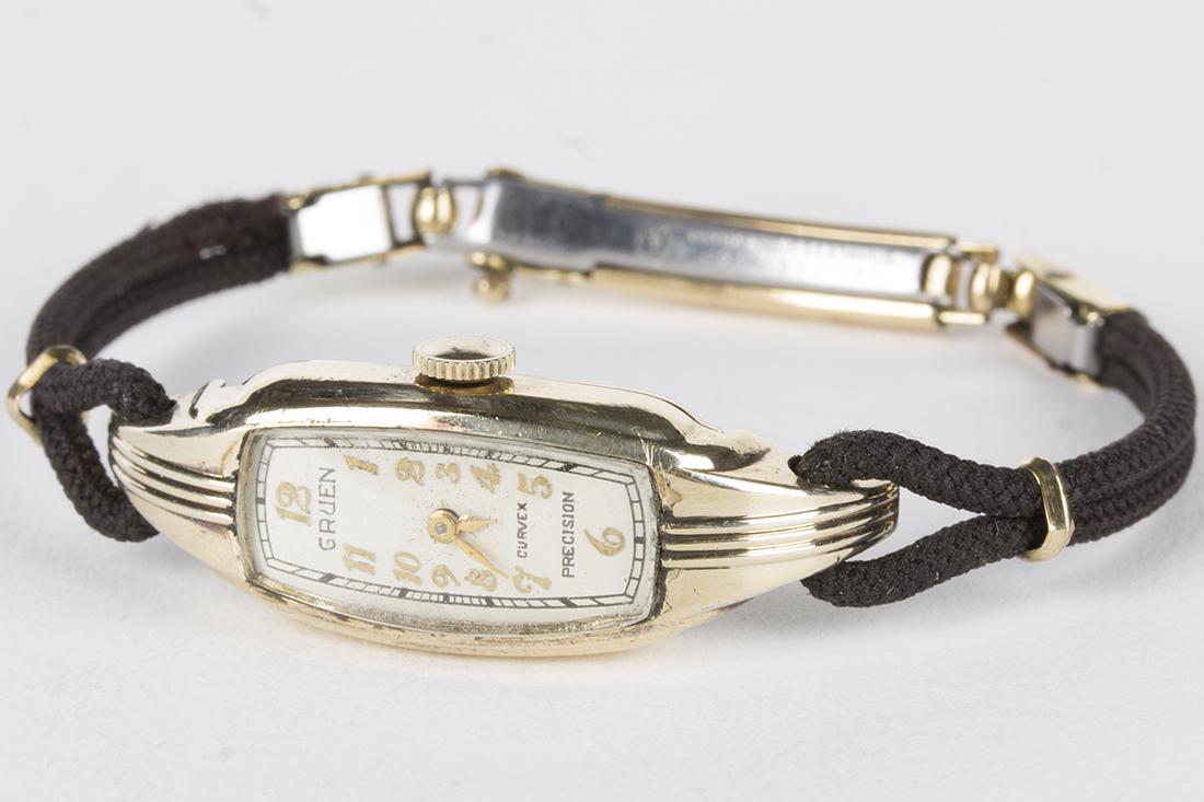 Vintage Gruen Curvex Precision Wristwatch: GRUEN Curvex Precision 17 jewel handwind wristwatch. Movement # 536572. Golden hands and Arabic numerals. Case by Wadsworth Case Co., 10kt gold filled, serial #G493023. 14mm case, loop lugs. Cloth ban