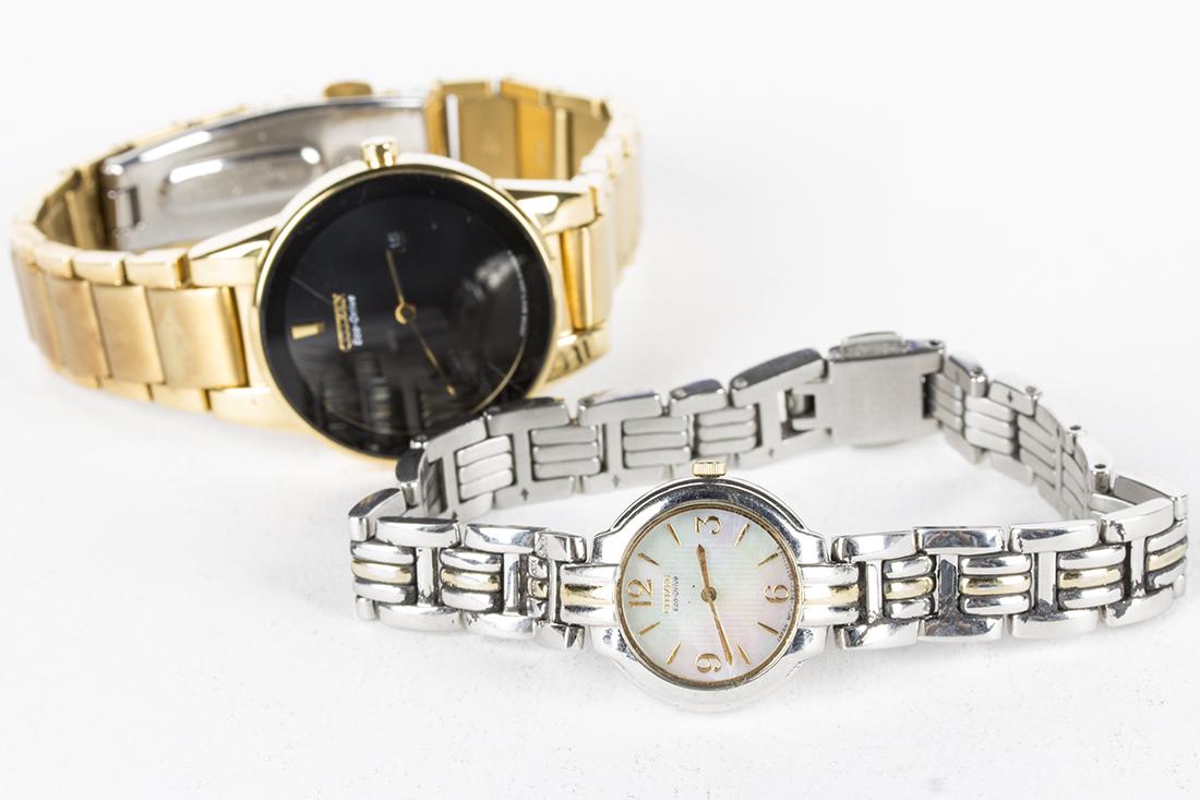 Lot of 2 Lady's Citizen Eco-Drive Wristwatches: A. Lady's CITIZEN Eco-Drive wristwatch with date window at 3 position. Gold tone stainless steel case and bracelet. Black face with gold hands. 36mm case. GN-0-S-9. Working and keeping time.B. Lady's