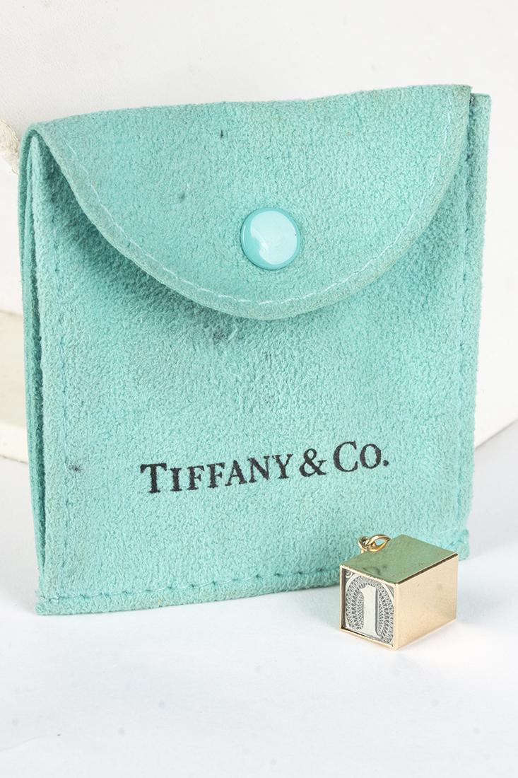 TIFFANY & CO 14KT "IN CASE OF EMERGENCY" Pendant: Tiffany & Co "In Emergency Break Glass" 14kt yellow gold charm/pendant. Pendant is 3/8" x 3/8" x 1/2" and contains a folded $1.00 bill. Stamped Tiffany & Co 14K.