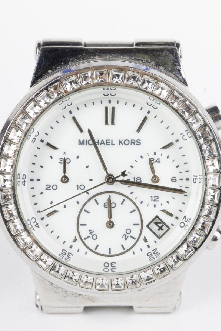 MICHAEL KORS Quartz Chronograph with Crystal Bezel: Michael Kors quartz chronograph with date at 4 position. All stainless case and bezel. White face with silver hands and hour marks. 3 subdials. Bezel is studded with crystals. MK5585. 251403. WP 10 