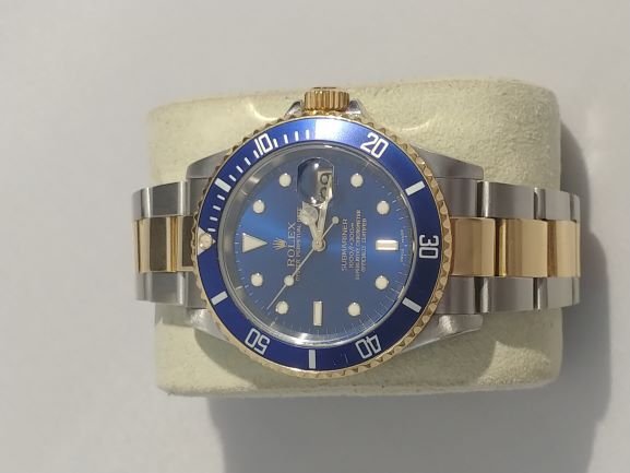 2004 ROLEX Submariner Stainless and 18KT Gold Watch: 2004 Rolex Submariner Swiss automatic with magnified date window at 3 position. Stainless steel case with 18kt yellow gold bezel. Marine blue face with luminescent minute marks and hands framed in gol