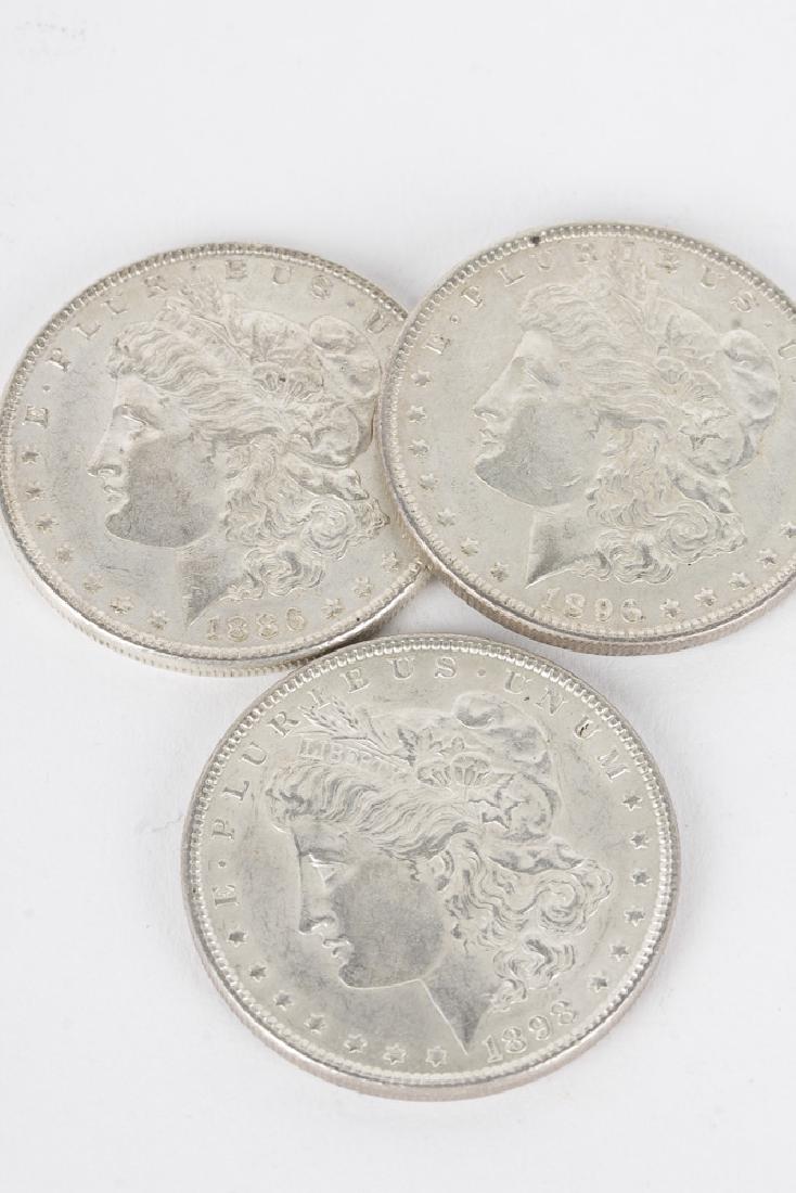 Lot of 3 90% Morgan Silver Dollars: An 1886, 1896, 1898 Morgan dollar in brilliant uncirculated condition. 90% fine silver, 0.7734 troy ounce pure silver per coin. 80.33g