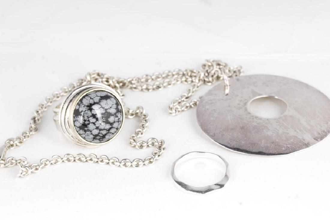 RL Morris STUDIO Sterling Silver: Robert Lee Morris Studio three piece sterling jewelry collection including 2 rings and a necklace. Necklace consists of a sterling pendant of approx 2.25" which has been holed at the center. Presented