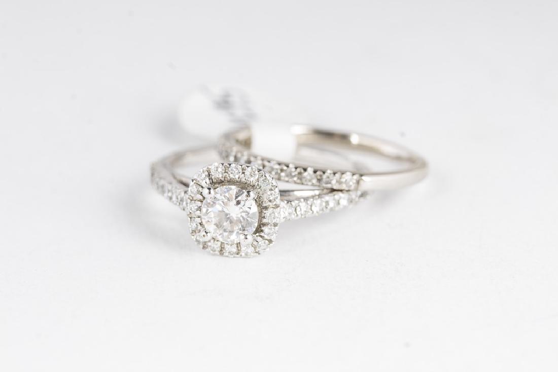 14KT White Gold & 1.4CTW Diamond Wedding Set: 14kt white gold wedding set. The engagement ring has a 0.45 carat round cut center diamond (4.95mm, H-I, S1) with a diamond halo and channel set diamonds in the band (approx 0.64 carats). Band has 0.3