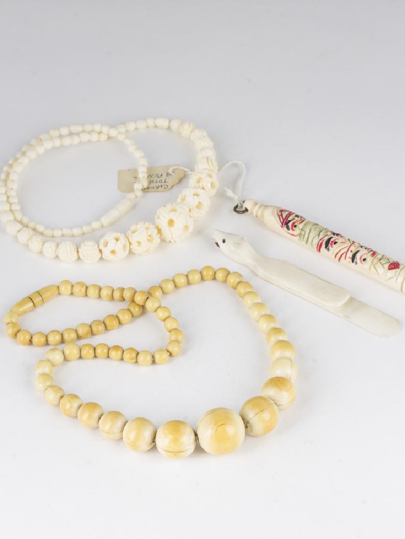 Two carved jewelry pieces totem pencil & carved: 2 Necklaces, 16" in length, one will smoothly carved beads 5mm to 18mm in diameter, and one intricately carved with 3mm to 16mm beads. Polar bear carved clip, 3.5" long. 3.5" long carved totem with in