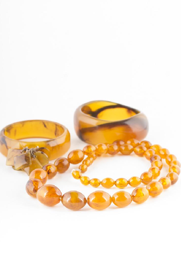 Collection of Costume Jewelry: Costume jewelry collection, unidentified material, acrylic or possibly bakelite. 2 bracelets, approx 2 3/4" in diameter and a necklace 26" in length, with beads beginning with 25mm x 20mm and descendi