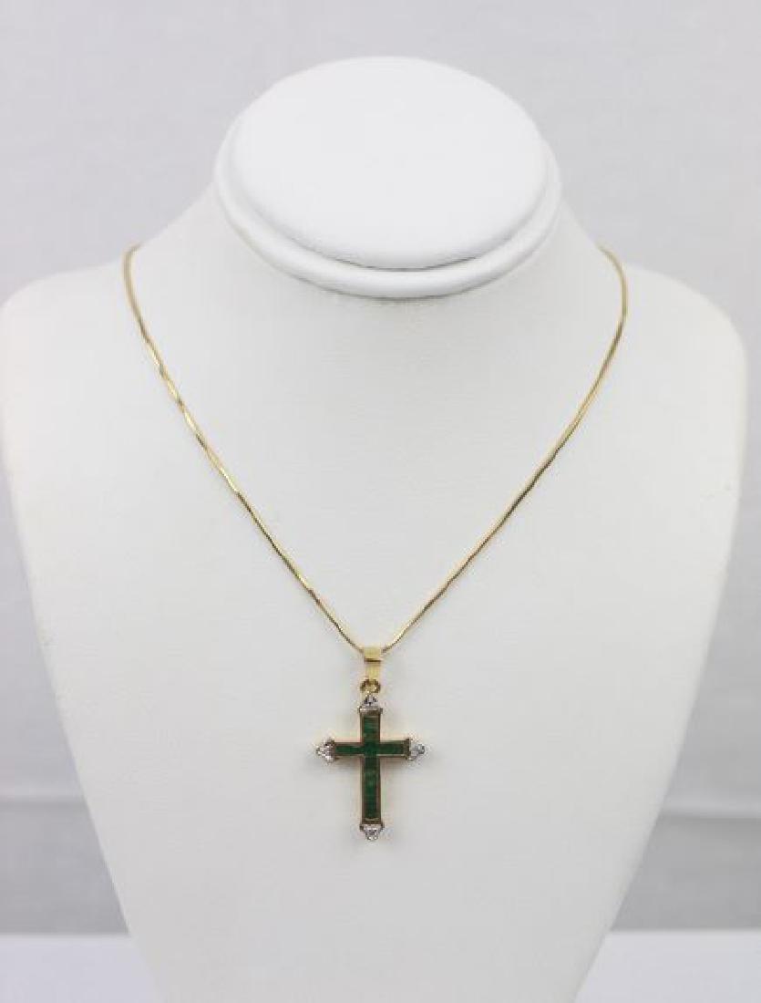 Emerald and Diamond Cross in 14kt Gold: Emerald and diamond cross set in 14kt yellow gold and presented on an 18" 14kt yellow gold chain. 12 square cut emeralds make up the body of the cross, while each end point is accented with a diamond.