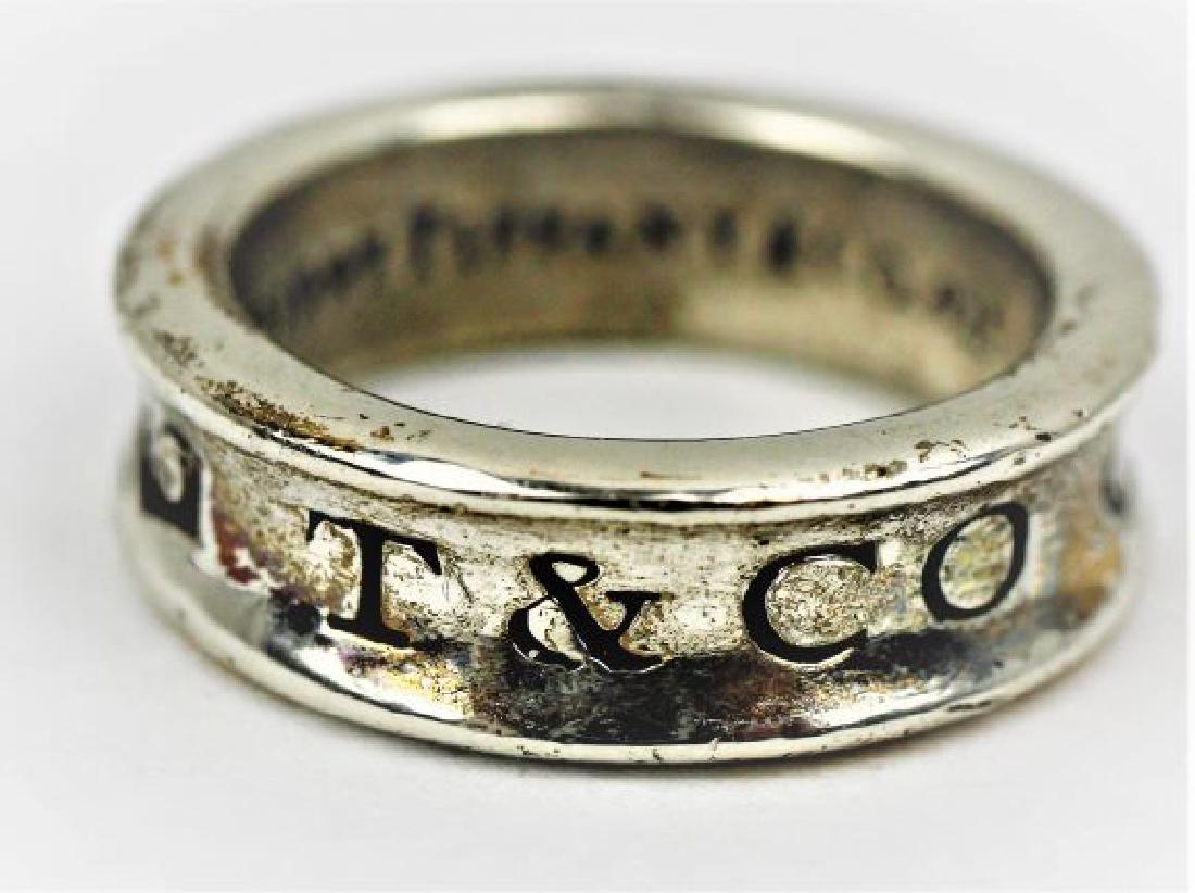 Tiffany & Co. Sterling Ring: A sterling silver ring from Tiffany and Co., size 5.5. Marked "925, T & Co, 1837" on the outside, and "c1997 Tiffany & Co. 925" on the inside. 7.75gms