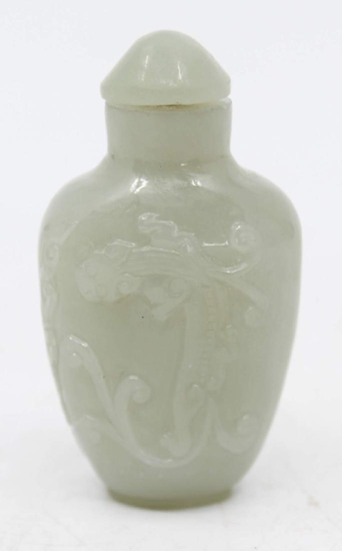 Antique Chinese Hand-Carved Jadeite Snuff Bottle: An antique Chinese jadeite snuff bottle. This piece features a hand-carved dragon design. It has a bone spoon. Dimensions: 2.5 x 1.75 x 1 Flat Rate Shipping (not calculated):