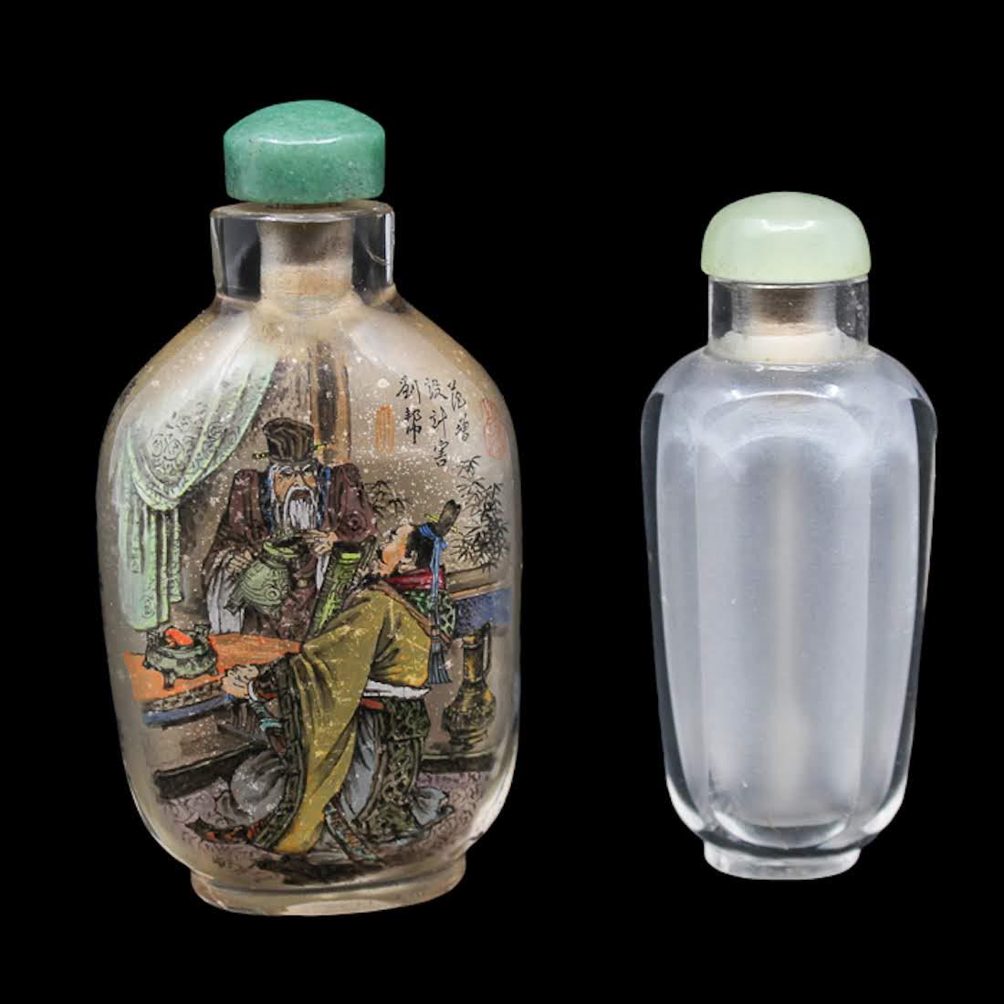 Antique Glass Snuff Bottles Including Reverse Painted: A grouping of two antique glass snuff bottles. This lot includes a reverse painted bottle with a metal spoon and a frosted glass bottle with a faux bone spoon. Dimensions: 3.25 x 1.75 x 1 (for reverse