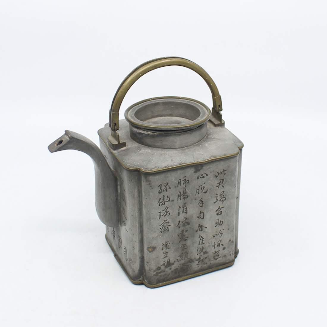 Antique Chinese Etched Pewter Teapot: An antique Chinese etched pewter teapot. This piece features Chinese lettering on two sides, a scene of a woman looking over a ledge on one side, and a scene of a bird perched in a tree on one side. I