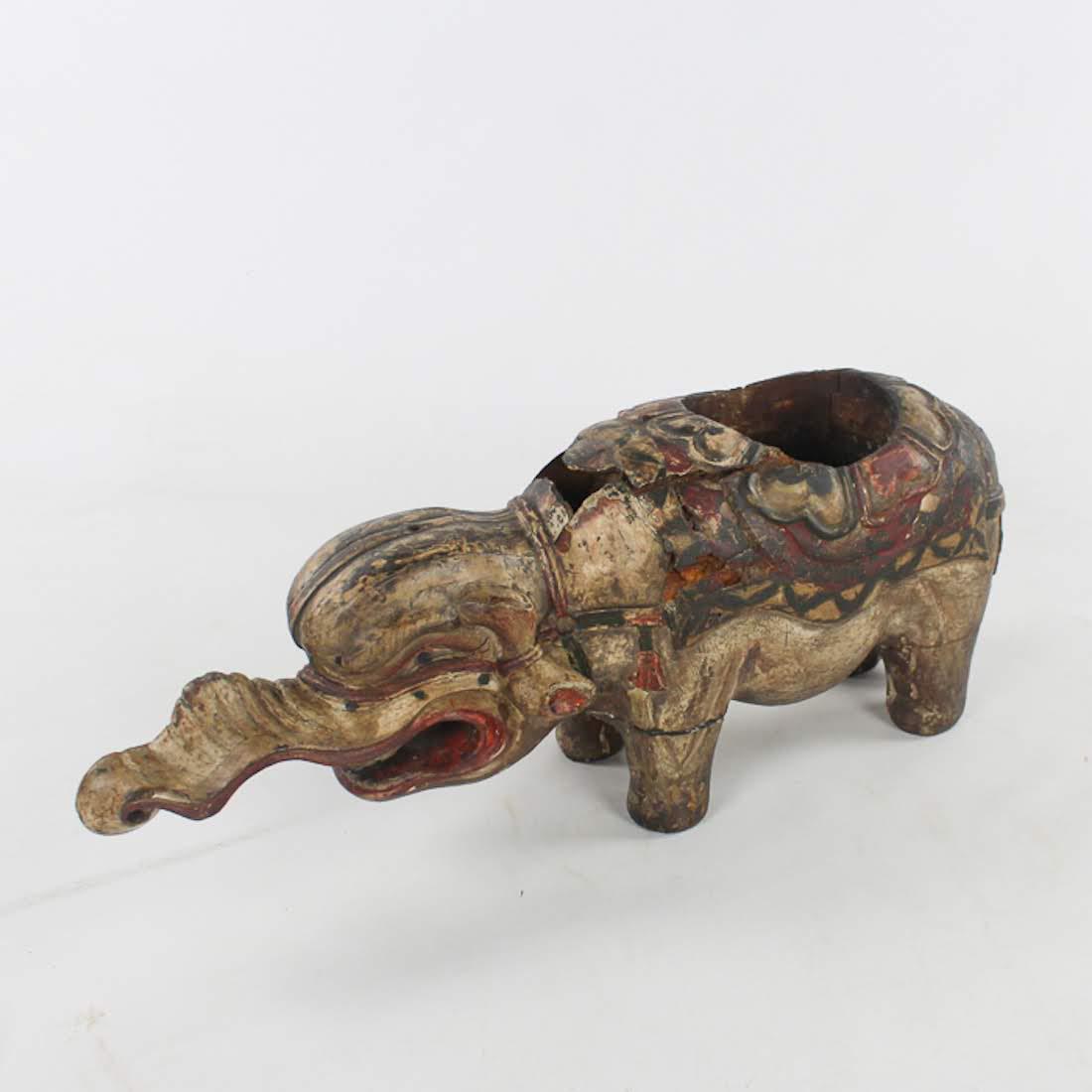 Antique Chinese Hand-Carved Wooden Elephant Planter: An antique Chinese hand-carved wooden elephant planter. This piece features an exaggerated trunk and hand-painted detailing throughout. It is unmarked. Dimensions: 9 x 22.5 x 5 Flat Rate Shipping (not