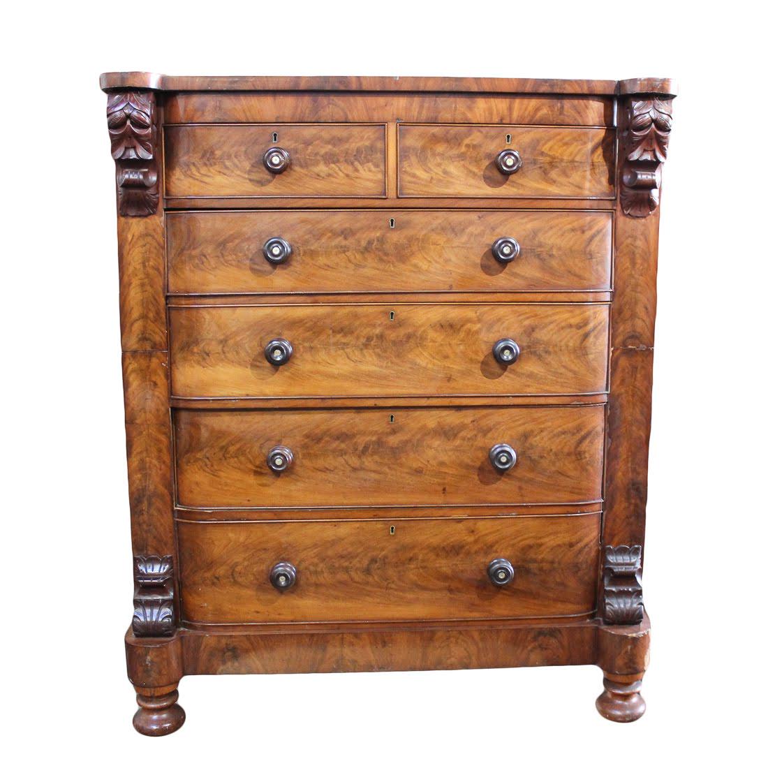 American Empire Flame Mahogany Highboy Dresser: An antique American Empire flame mahogany highboy dresser. This piece has two side-by-side locking drawers above four stacked locking drawers, all featuring dovetail construction. It also features car