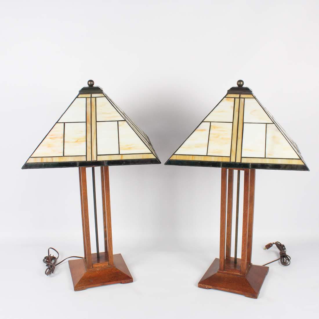 Pair of Stickley Mission Collection Table Lamps: A pair of Stickley Mission Collection double-light table lamps. Each lamp features a Tiffany style stained glass triangular shade and open-work oak body. They are unmarked. Table Lamp (89-041-11): htt