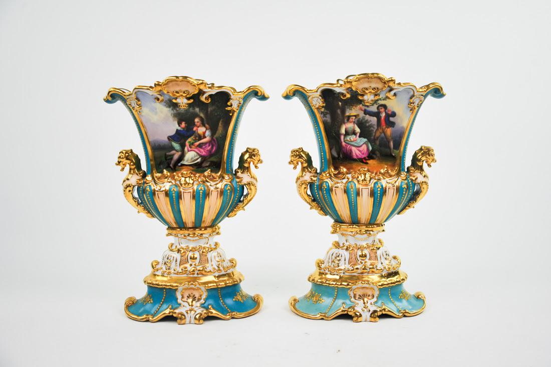 Pair of Antique Sèvres Vases: A pair of antique Sèvres vases. Each vase features a hand-painted design of a man and woman on one side and a flora and fauna design on the other with gilt detailing throughout. They are unmarked. Di
