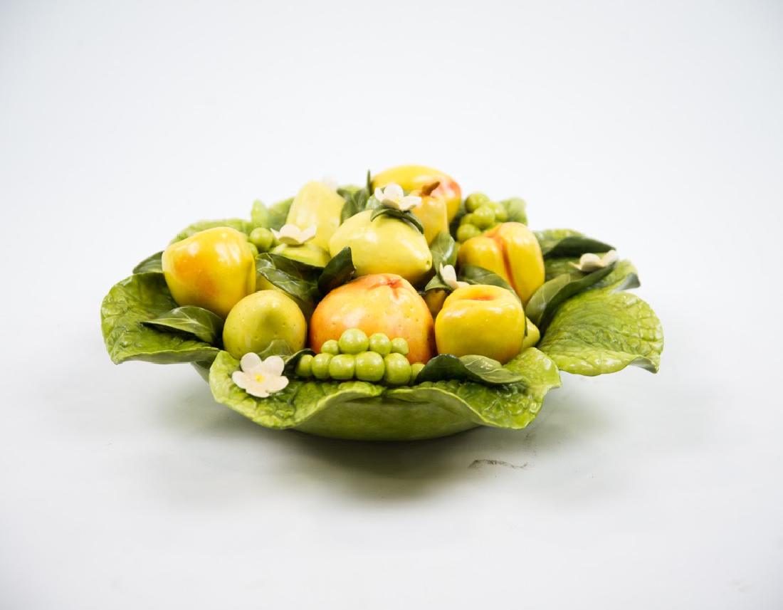 Signed Ceramic Fruit Bowl Sculpture c. 1999: A ceramic fruit bowl sculpture circa 1999. This work depicts a bowl constructed of leaves full of various fruit, including apples, oranges, and lemons. There are tiny white flowers amongst the fruit a