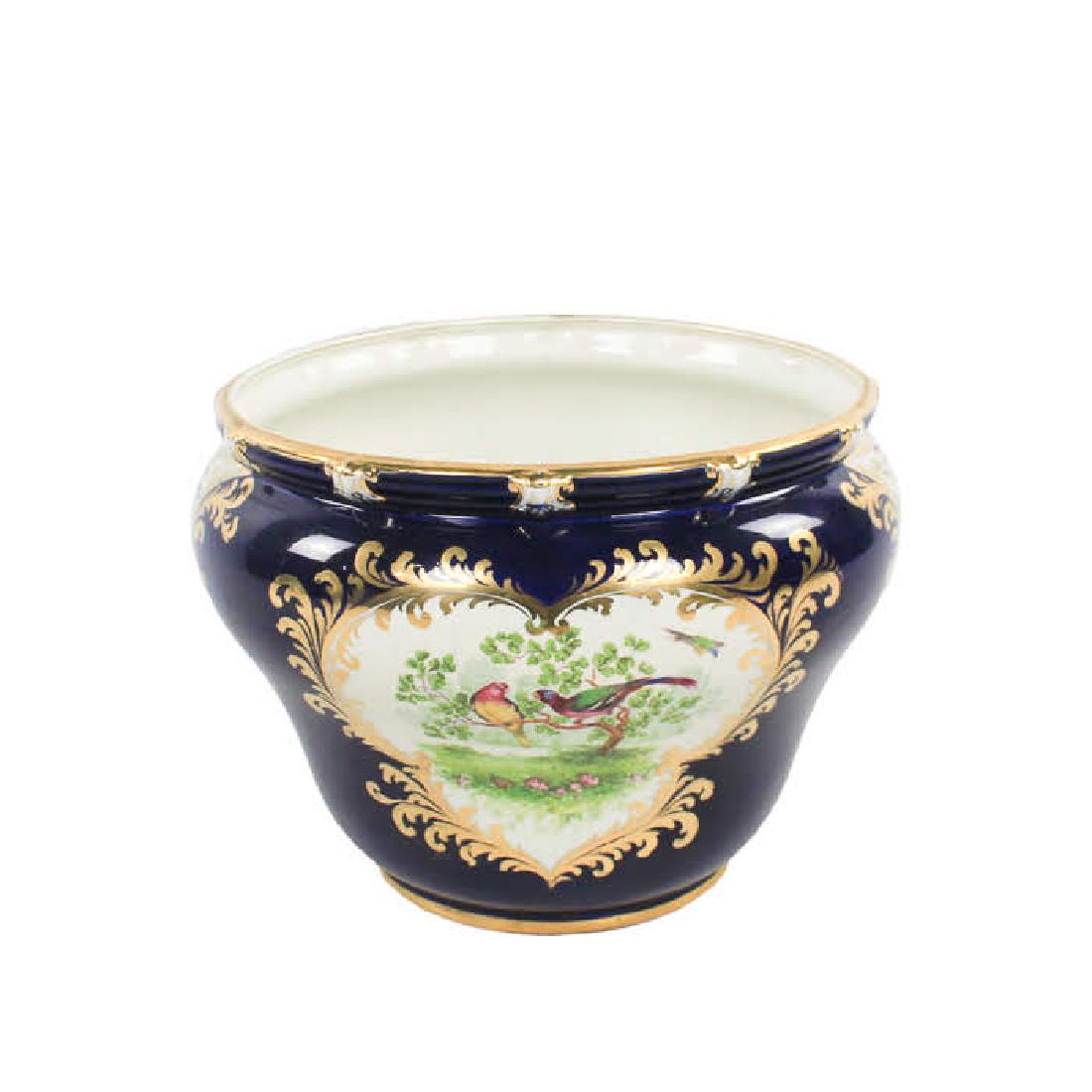 Antique George Jones & Son "Crescent" Porcelain: An antique George Jones & Son "Crescent" porcelain jardiniere. This piece features hand-painted bird and floral designs over a cobalt blue base with gilt detailing throughout. It is marked on the unde