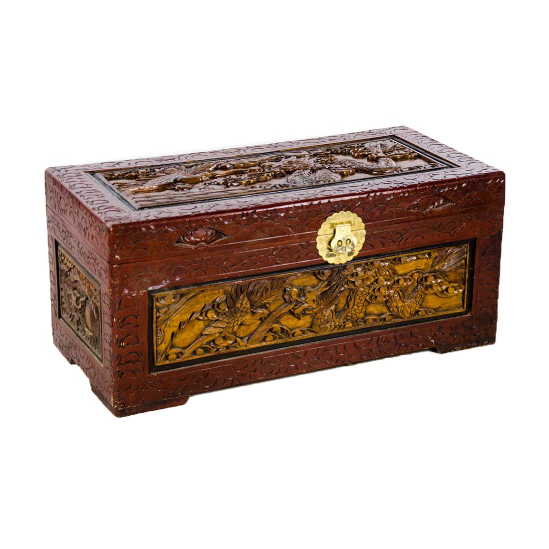 Chinese Carved Camphor Wood Chest: A vintage Chinese camphor wood chest. This piece is heavily carved on all sides featuring a phoenix and dragon motif. In addition, this piece features an etched brass closure. The interior of the lid 