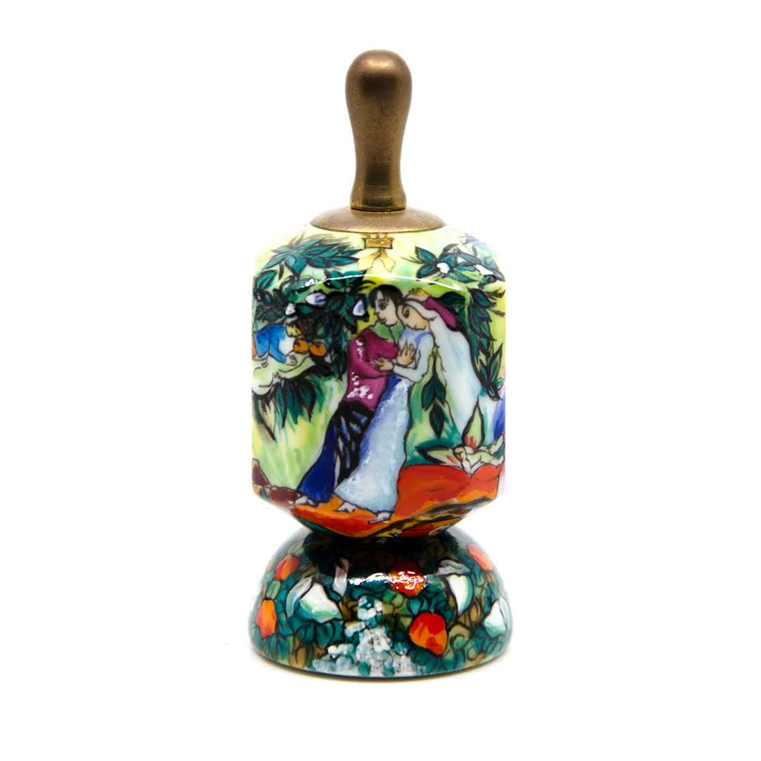Zvezdin's Workshop Hand-Painted Porcelain Dreidel: A vintage Zvezdin's Workshop hand-painted porcelain dreidel with stand. This piece features vibrant Judaica designs throughout with gilt detailing. It is marked with Zvezdin's maker's mark on the unde