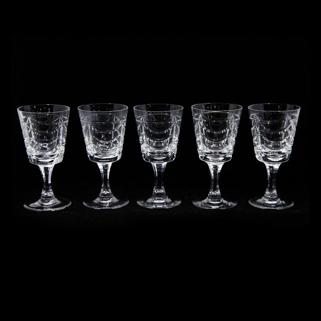 Set of Twenty Brierley Crystal White Wine Glasses: A set of twenty Brierley crystal white wine glasses. Each glass features a repeating drape design throughout the body. They are marked "Brierley" on the underside. The pattern number for this set is R