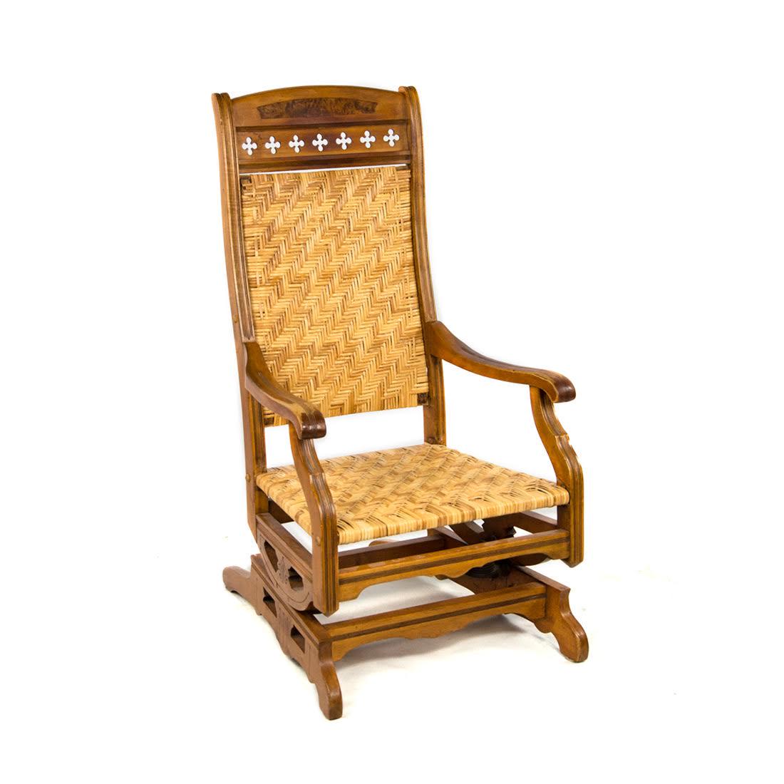 Victorian Eastlake Cane Rocking Chair: An antique Victorian Eastlake cane rocking chair. This piece features a herringbone weave cane seat and back, as well as a crest with cross cut-outs. This piece is unmarked. Dimensions: 42"H x 22.5"W 