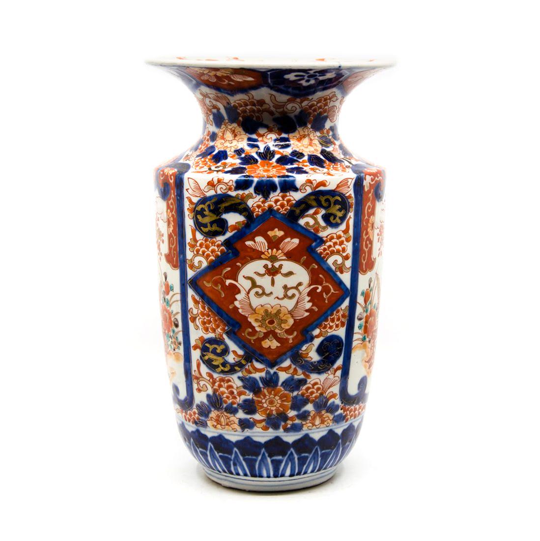 Antique Imari Hand-Painted Porcelain Vase: An antique Imari hand-painted porcelain vase. This piece features hand-painted floral, foliate, and geometric designs throughout in a palette of blue, red, and gold. There is a depiction of a bird lan