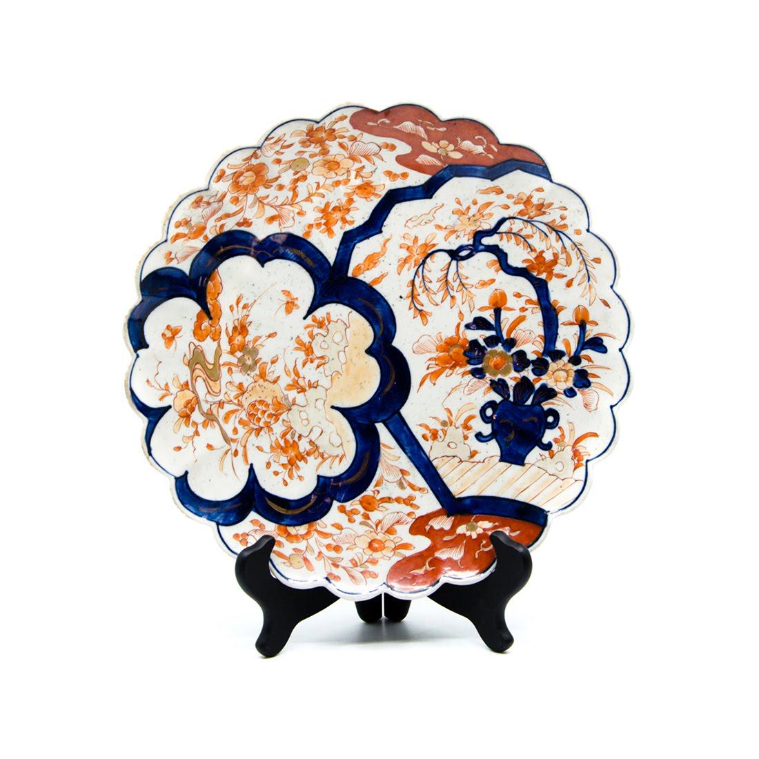 Antique Imari Hand-Painted Porcelain Platter: An antique Imari hand-painted porcelain platter. This piece features a paneled design with varying floral depictions within each section. It also features a heavily scalloped rim. This piece is unmark