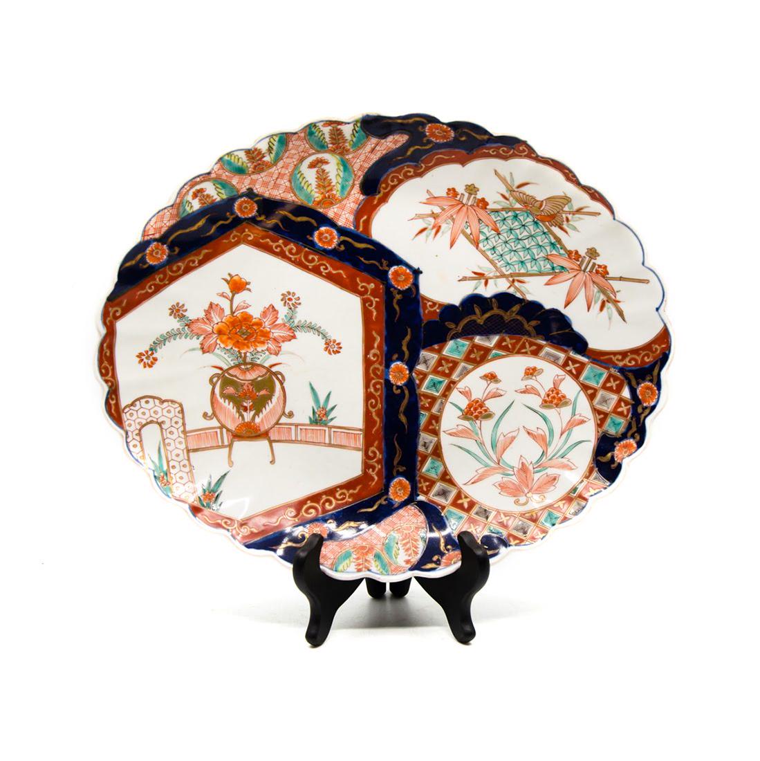 Antique Imari Hand-Painted Porcelain Platter: An antique Imari hand-painted porcelain platter. This piece features a paneled design with a varying floral arrangement depiction within each section. It is completed with a scalloped border. This pie