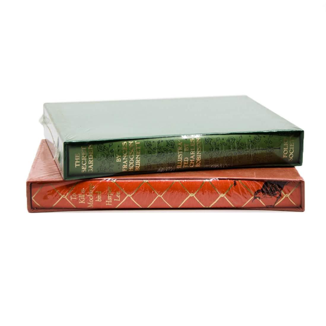 Gilded Hardcover Books Published by The Folio Society: A grouping of two gilded hardcover books in their original shrinkwrap. This lot includes "To Kill A Mocking Bird" by Harper Lee (The Folio Society; London; 1999) and "The Secret Garden" by Francis Hod