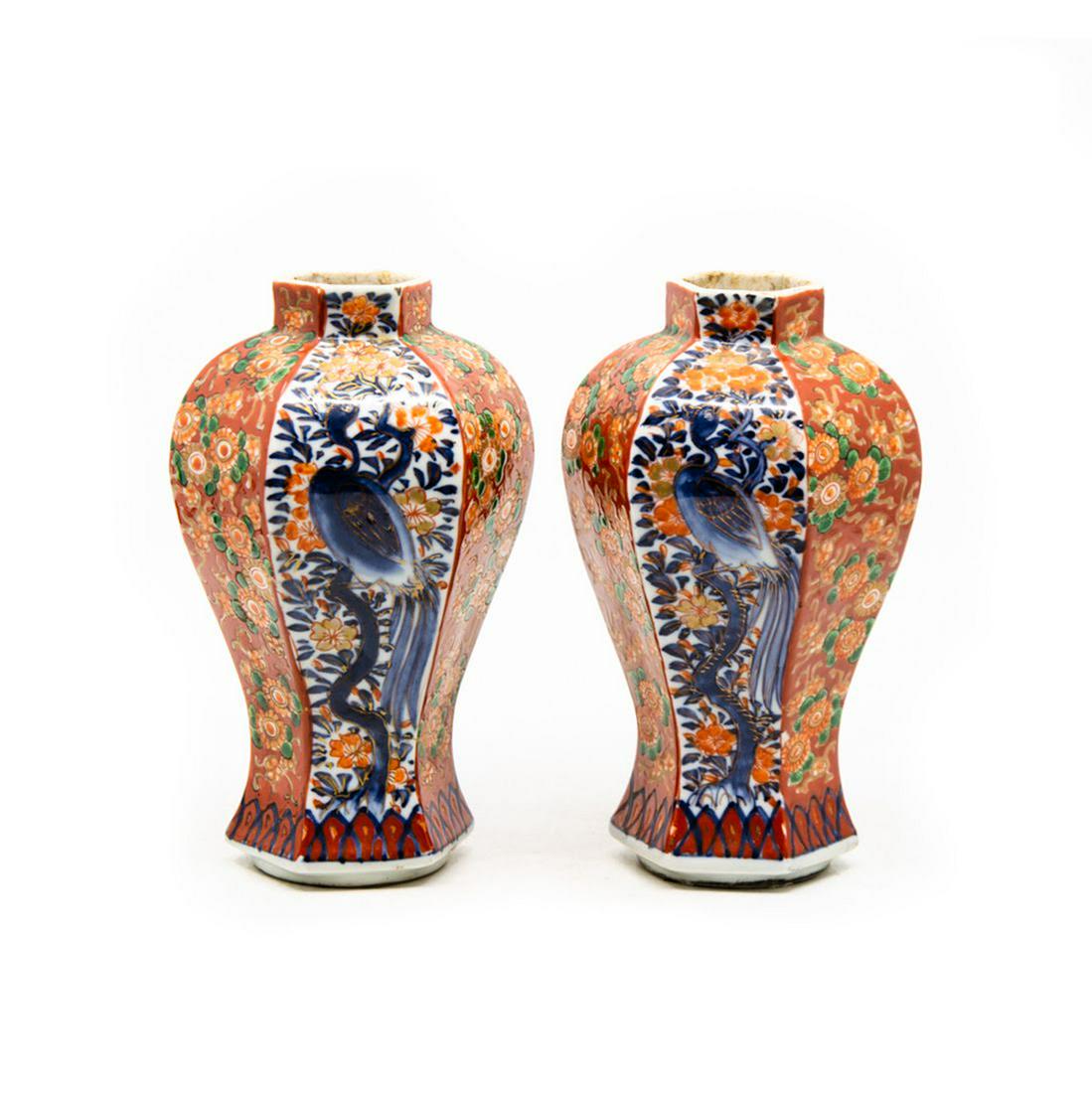 Antique Imari Hand-Painted Porcelain Vases: A pair of antique Imari hand-painted porcelain vases. Each vase features a six-paneled form with each panel alternating between a floral design and a crane design. They are unmarked. Condition: Wear c