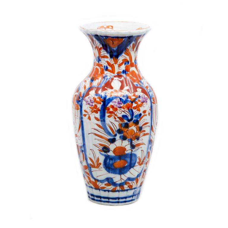 Antique Japanese Imari Vase: Small Japanese Imari porcelain vase with traditional colors and motifs. Has flaw from firing process that has created a horizontal band indentation visible from the inside and outside. Some very minor