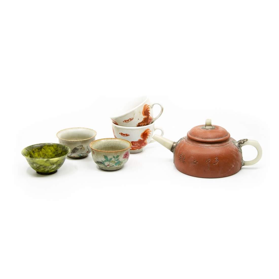 Group of Chinese Teacups and Teapot: A group consisting of a Chinese Yixing Clay teapost having a jadeite spout and handle and top knob with possibly silver fittings, two teacups floral and bird -motifs, two teacups with red painted qili