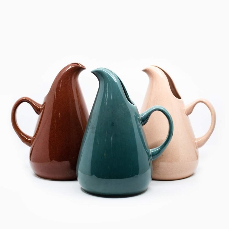 3 MCM Iroquois Casual Pitchers by Richard Wright: Group of three Mid-century Modern Iroquois Casual Dining ceramic serving pitchers by Russel Wright. Assorted colors of turquoise, rust red, and salmon pink. Each piece measures 10.25" x 9" x 20.5"