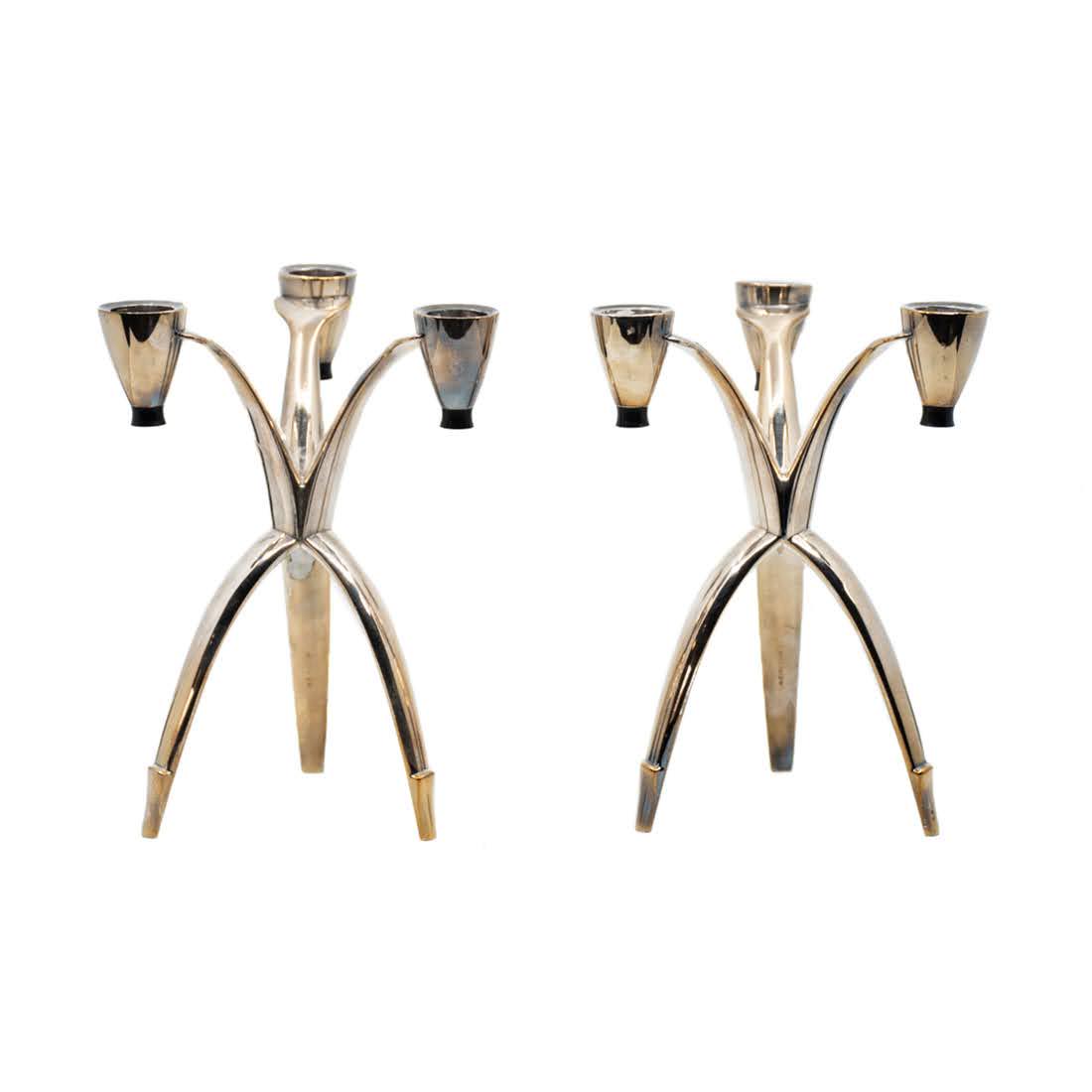 Pair of HEIRLOOM Streamlined Silver Plated Tripod: A pair of HEIRLOOM streamlined silver plated tripod candelabras. Both pieces are marked, "HEIRLOOM" on the inner leg. In good condition with wear commensurate with age and use. Both pieces measure 7.5
