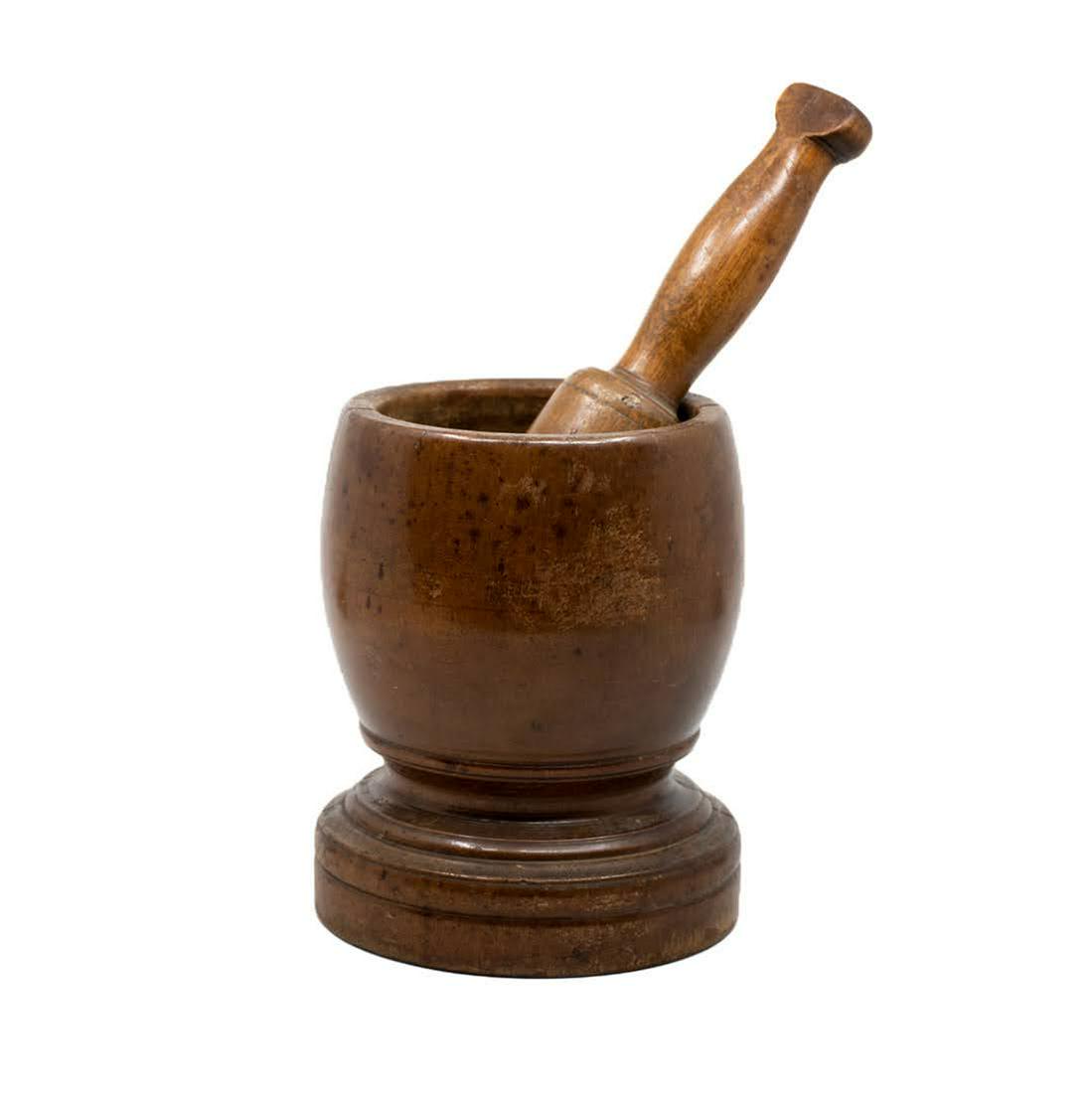 Wood Carved Mortar and Pestle Set: A vintage wooden mortar and pestle with a carved base. It has two cracks on the mortar and is unmarked.