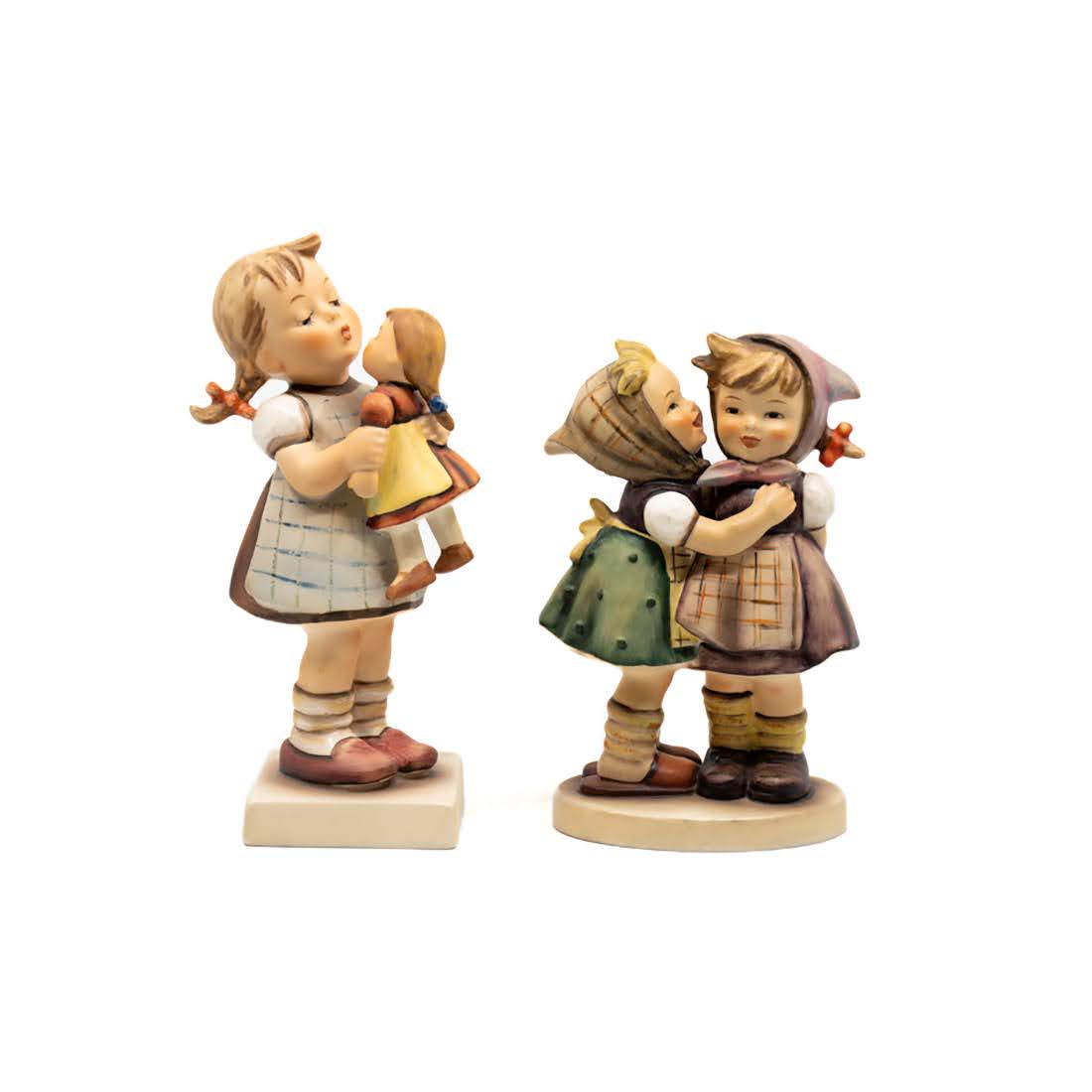 Goebel Hummel Kiss Me 311 and Telling Her Secret 196/0: Goebel Hummel #311 Kiss Me TMK 6 figure, featuring a young girl kissing her doll and #196/0 Telling Her Secret TMK 4 figure, featuring two young girls as one whispers into the others ear.