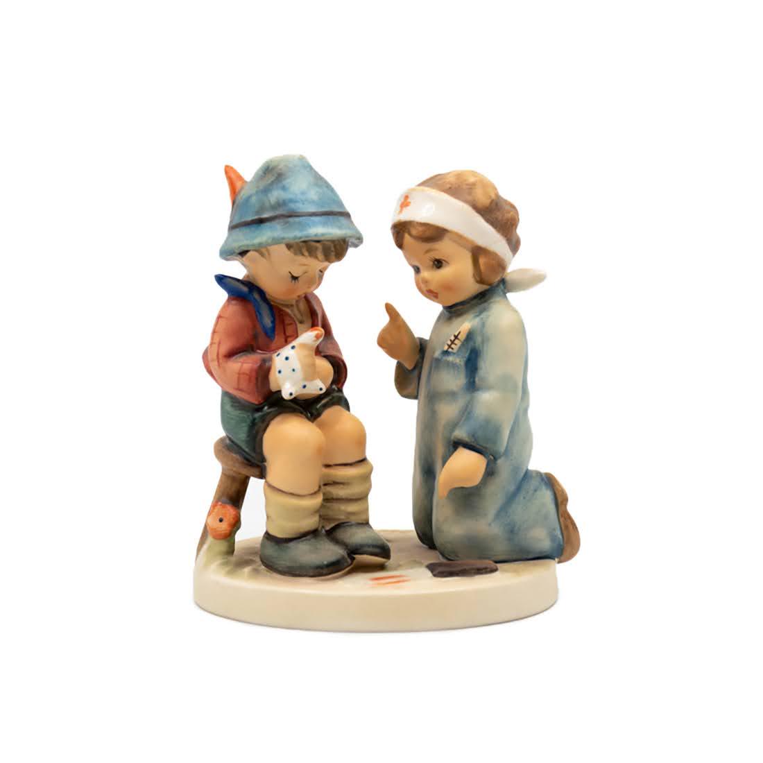 Goebel Hummel Little Nurse 376 Figurine: Goebel Hummel #376 Little Nurse TMK 6 figure, featuring a young girl dressed as a nurse assisting a young boy in a hat with a cloth wrapped around his hand.