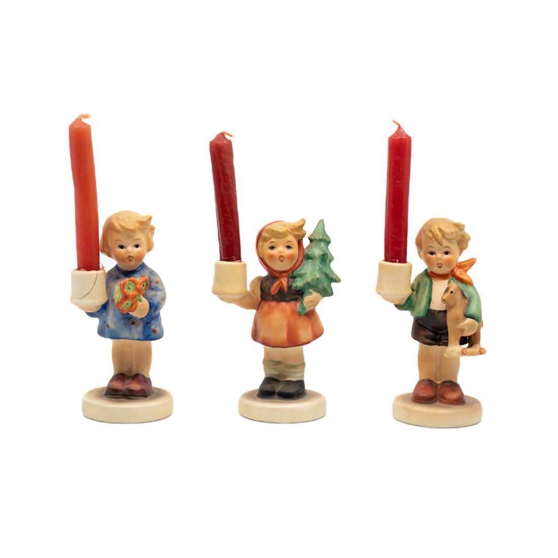 Group of 3 Goebel Hummel 115, 116, 117 Candle Figurines: Goebel Hummel #115 Girl with Nosegay TMK 3 candle, #116 Girl with Fir Tree TMK 3 candle, and #117 Boy with Horse TMK 3 candle. Each features a young girl or boy holding a small candle holder.