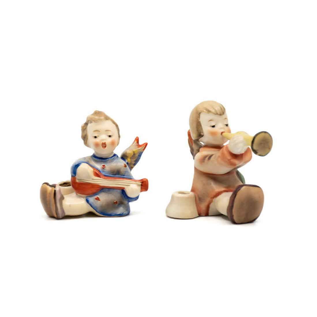Goebel Hummel 27/1 and 40/0 Candle Holders: Goebel Hummel #27/1 Joyous News with Lute candle holder, featuring an angel playing a lute and #40/0 Joyous News with Trumpet TMK 3 candle holder, featuring an angel playing the trumpet.