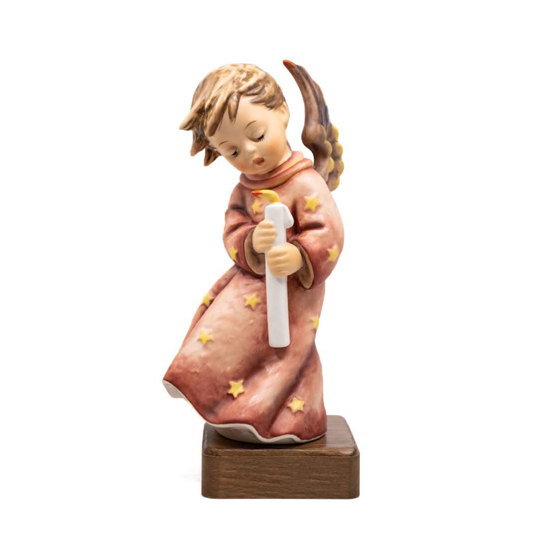 Goebel Hummel Heavenly Angel 755 Figurine: Goebel Hummel #755 Heavenly Angel TMK 7 figure, featuring a tall angel in a star covered robe holding a small candle with wings splayed. This figure is a tree topper and comes with a wooden stand.