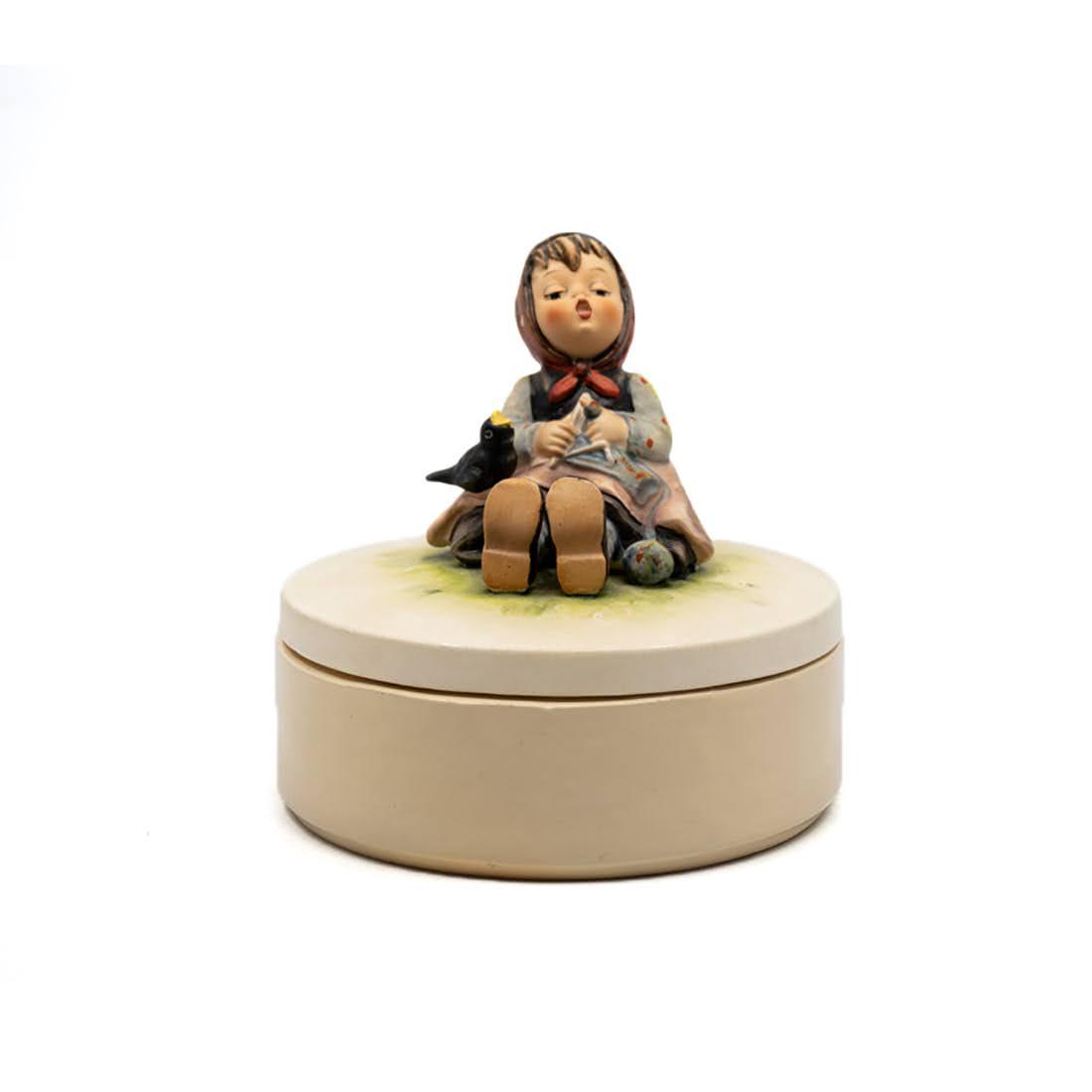 Goebel Hummel Happy Pastime 111/69 Porcelain Dish: Goebel Hummel #111/69 Happy Pastime TMK 5 covered dish, featuring a young girl knitting with a black bird on her lap. It has a new, straight-style porcealin dish.