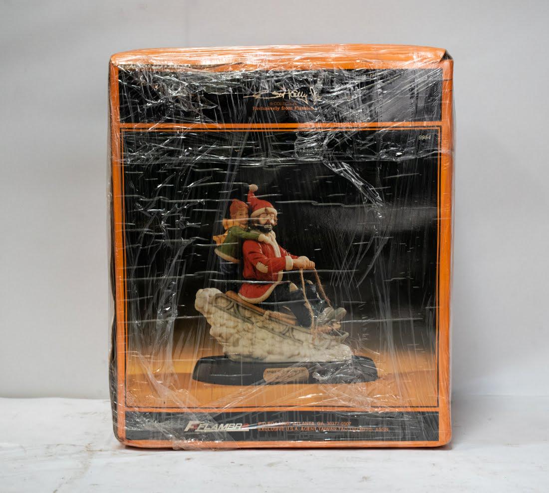 Emmett Kelly Jr "Spirit of Christmas VIII" Clown: An Emmett Kelly Jr "Spirit of Christmas VIII" Clown figure, featuring a clown on a sled in a santa costume with a child on his back. It is marked on the underside.