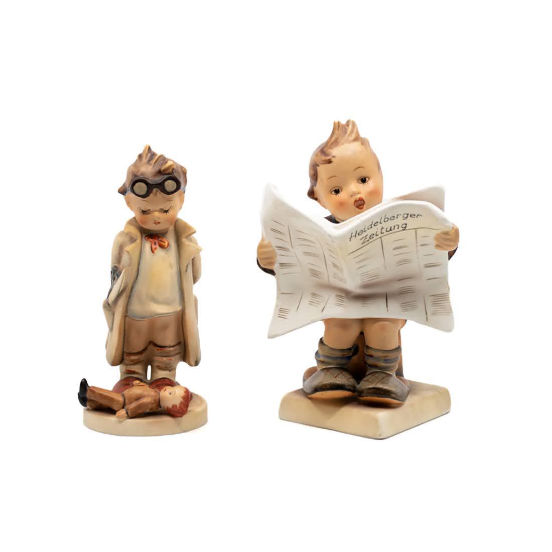Goebel Hummel The Doctor 127 and Latest News 184: Goebel Hummel #127 The Doctor TMK 2 figure, featuring a young boy dressed as a doctor with a doll at his feet and #184 Latest News TMK 2 figure, featuring a young boy holding a newspaper reading "Heid