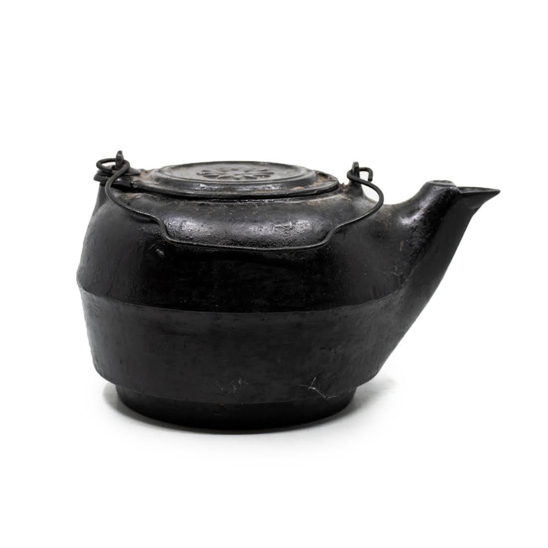 Black Cast Iron Lidded Tea Kettle No. 8: Black cast iron no. 8 lidded tea kettle with handle and medallion motif on lid. Measures 6.25 x 12 x 9.