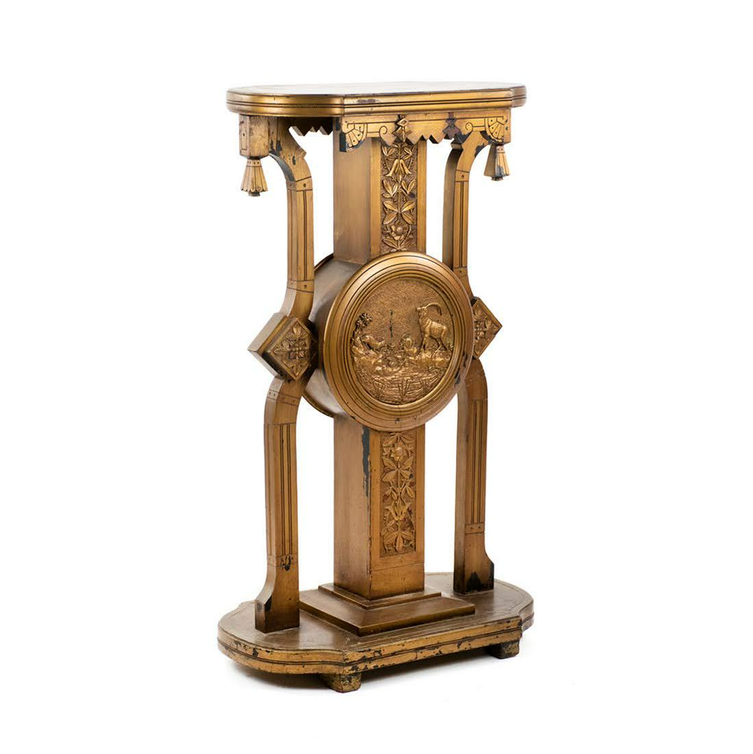 East Lake Victorian Plant Stand Pedestal: An Eastlake style Victorian (Late 19th Century) gold painted ebonized wood plant stand or pedestal having carved reliefs of flowers and rectilinear designs with large center medallion different nature