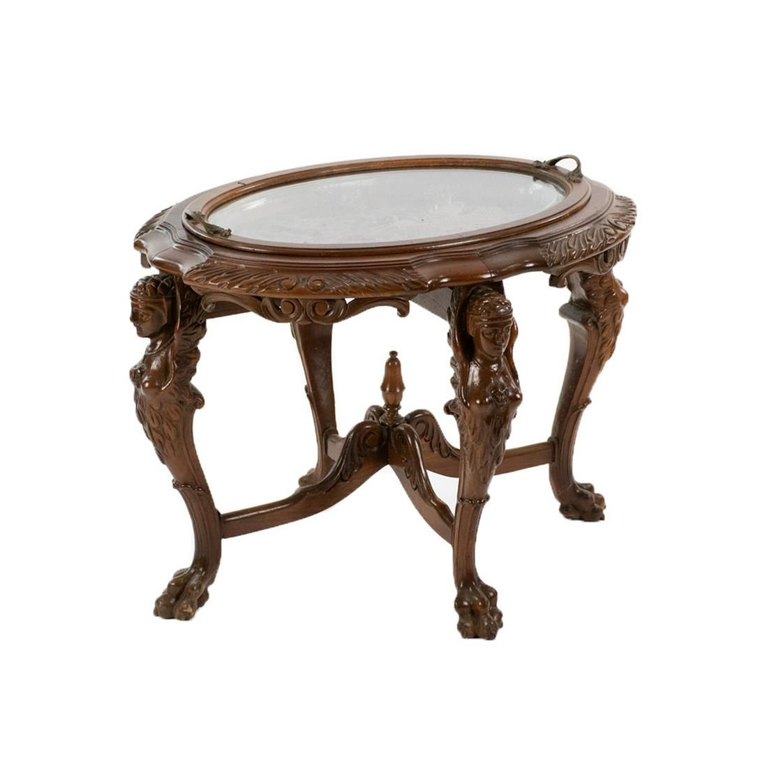 Art Nouveau Style Carved Glass Top Tray Table: An Art Nouveau style carved tray opium table having removable glass top with brass handles. Table depicts heavily carved female figures on the table and all four legs, terminating in claw feet. Unmark