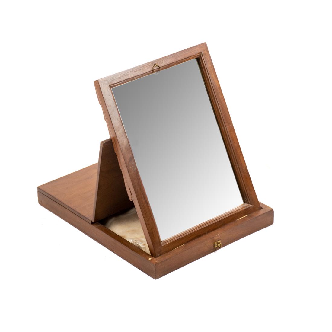 Vintage Traveling Table Top Mirror: A vintage traveling table top mirror housed in a wooden case with brass hardware. The case opens to reveal a mirror with beveled edge that can be propped up against the case lid to use. Brass plaque a