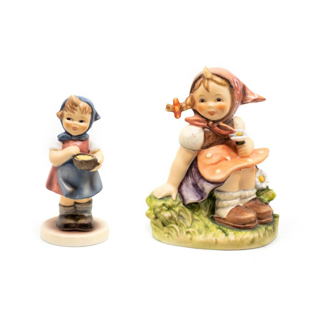 Goebel Hummel In the Meadows 459 and From Me to You 629: Goebel Hummel #459 In the Meadow TMK 6 features a girl sitting in a meadow while holding a daisy, #629 From Me to You TMK 7 features a girl offering a bowl of food.